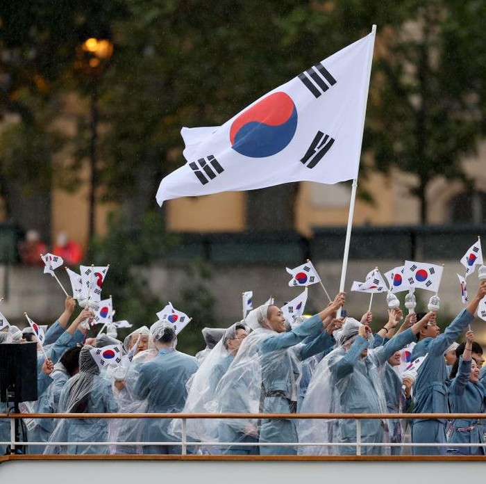 PARIS, FRANCE - JULY 26: Seoyeong Kim and Sanghyeok Woo, Flagbearers of Team Republic of Korea, are seen waving their flag along the River Seine during the opening ceremony of the Olympic Games Paris 2024 on July 26, 2024 in Paris, France. (Photo by Richard Pelham/Getty Images)