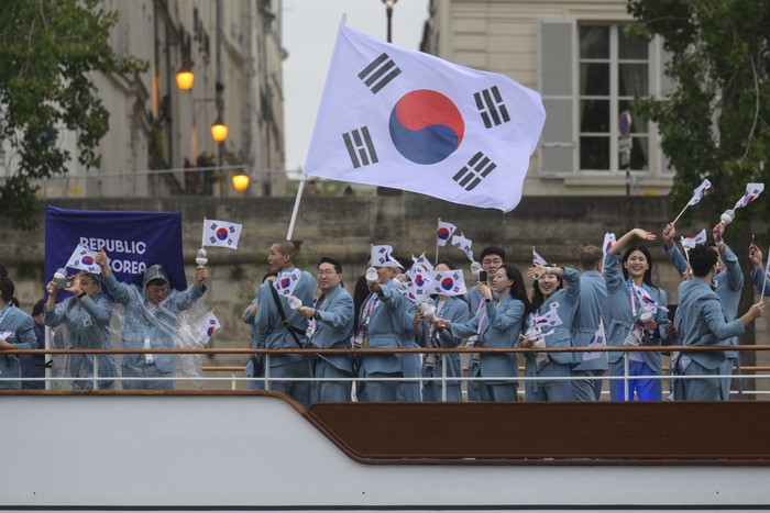 PARIS, FRANCE - JULY 26: Athletes from Republic of Korea delegation sail in a boat along the river Seine as rain starts at the start of the opening ceremony of the Paris 2024 Olympic Games in Paris, France on July 26, 2024. (Photo by Mehmet Murat Onel/Anadolu via Getty Images)