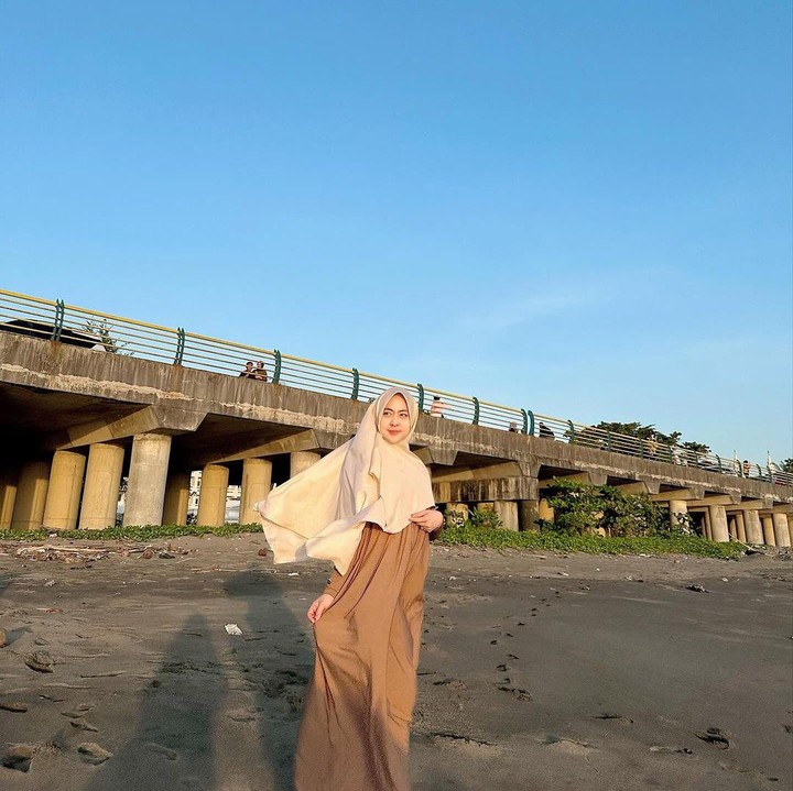 <p>Shindy membagikan potret baby bump kehamilan keduanya. Kakak YouTuber Ria Ricis ini tampil glowing mengenakan pakaian terusan berwarna cokelat susu yang dipadukan dengan jilbab berwarna cokelat muda. (Foto: Instagram @dr.shindyputri_)</p>