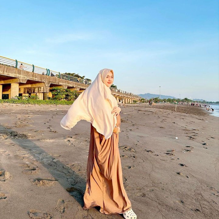 <p>Shindy memamerkan baby bump kehamilannya ini di pinggir pantai, Bunda. Pemandangan awan biru yang indah dengan pantai pasir berwarna keabu-abuan membuat foto ini terlihat estetik. (Foto: Instagram @dr.shindyputri_)</p>