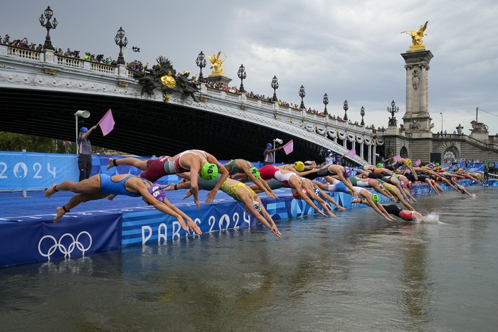 Athletes dive into the water for the start of the women's individual triathlon competition at the 2024 Summer Olympics, Wednesday, July 31, 2024, in Paris, France. (AP Photo/Vadim Ghirda)