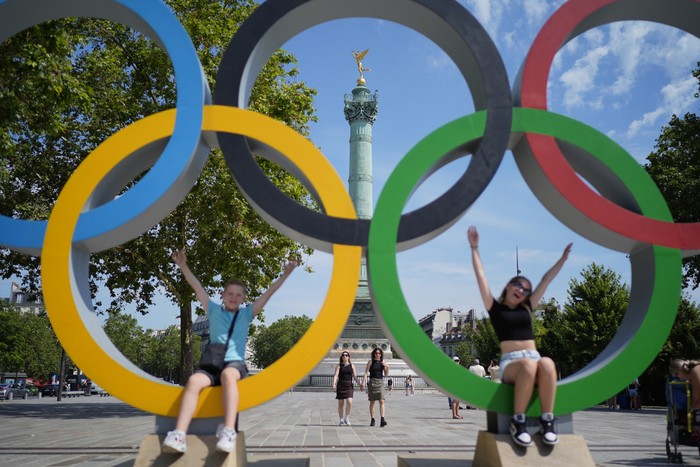 Kids play in Olympic rings set up on Place de la Bastille, Friday, July 19, 2024, in Paris, France. (AP Photo/David Goldman)