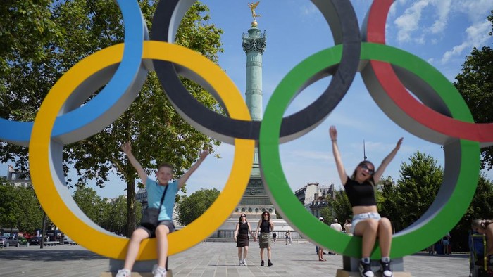 Kids play in Olympic rings set up on Place de la Bastille, Friday, July 19, 2024, in Paris, France. (AP Photo/David Goldman)