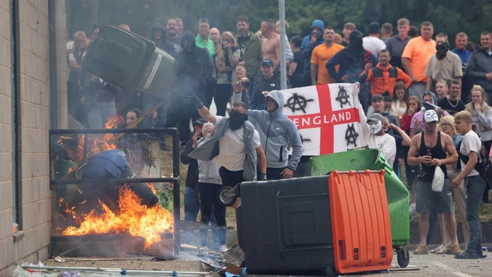 Demonstran melemparkan tong sampah selama protes anti-imigrasi, di Rotherham, Inggris, 4 Agustus 2024. (REUTERS/Hollie Adams)