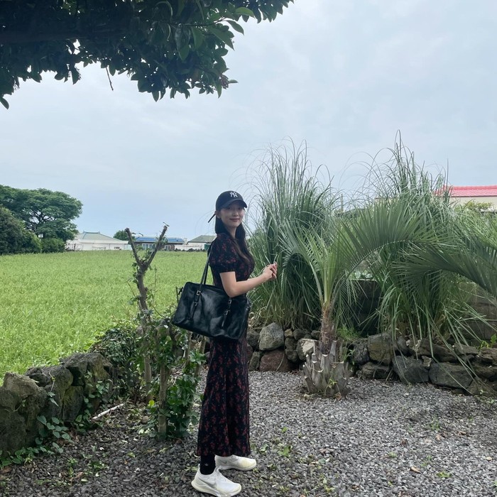 Pyo Ye Jin memadukan long dress bermotif bunga yang cantik dengan sepatu kets putih. Ia menambahkan topi dan tas hitam yang membuatnya tampil casual namun tetap feminin. / Foto: Allure Korea