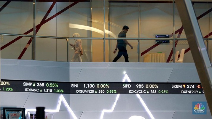 Pegawai berjalan dibawah layar pergerakan Indeks Harga Saham Gabungan (IHSG) di Bursa Efek Indonesia (BEI), Jakarta, Selasa (6/8/2024). (CNBC Indonesia/Muhammad Sabki)