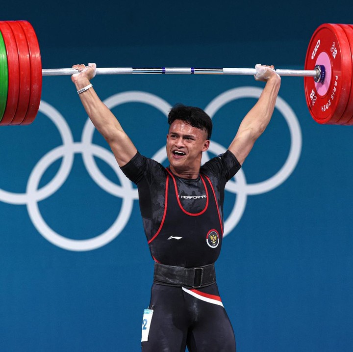 <p>Nama Rizki Juniansyah tengah menjadi sorotan publik setelah meraih medali emas di Olimpiade Paris 2024. Bukan hanya itu, atlet angkat besi asal Banten ini juga berhasil bikin rekor di angkatan clean & jerk. (Foto: REUTERS)</p>