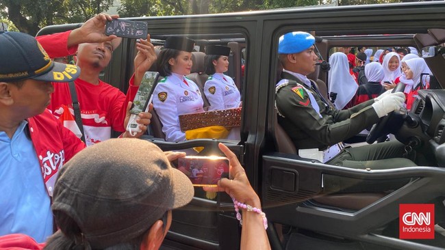 Warga tumpah ke jalan saat salinan bendera pusaka Merah Putih dan teks original proklamasi dikirab dari Monas ke Landasan Udara Halim Perdanakusuma, Sabtu (10/8).