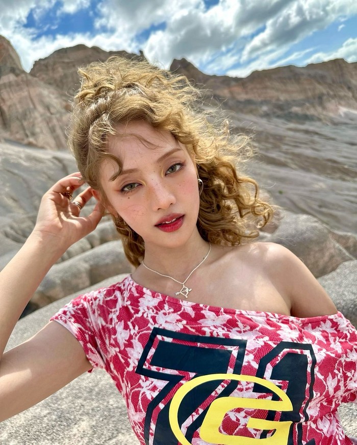 Dalam salah satu comeback, Minnie melakukan transformasi berani dengan gaya rambut ikal dan warna rambut cerah. Tampilan itu dipadukan dengan makeup yang fresh, dan atasan off-the-shoulder yang membuatnya semakin menonjol. / Foto: Elle Korea