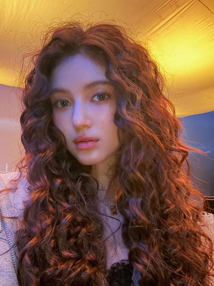 Gaya rambut ikal Danielle sukses meningkatkan suasana funky dengan menambahkan gelombang dari akar hingga ujung rambut. Lebih uniknya, rambut ikal adalah rambut asli Danielle yang membuat look-nya semakin cantik dan karismatik. / Foto: Elle Korea