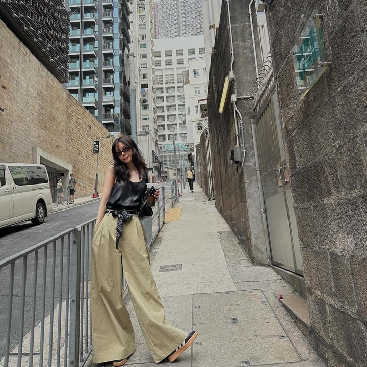 <p>Outfit Son Naeun berikut ini juga tak kalah modis. Ia memadukan celana kulot <em>oversized</em> dengan <em>tanktop</em> berbahan satin warna hitam. Ia menyempurnakan penampilan dengan <em>slayer</em> yang diikat pada <em>belt.</em> (Foto: Instagram @marcellasne_)</p>