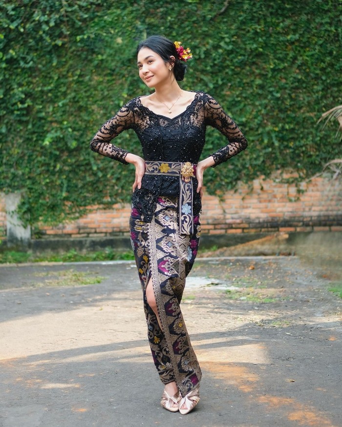 Sebagai Tenaga Ahli Menteri bidang Komunikasi Publik, Mikha Tambayong turut merayakan Hari Kemerdekaan Indonesia bersama Kementerian Pemuda dan Olahraga RI. Ia mengenakan kebaya Bali warna hitam rancangan Fadlan. Kebaya modern berbubuh payet tersebut berkesan lebih glamor berkat bros emas pada obi serta kain songket yang dipadukannya/ Foto: Instagram.com/miktambayong