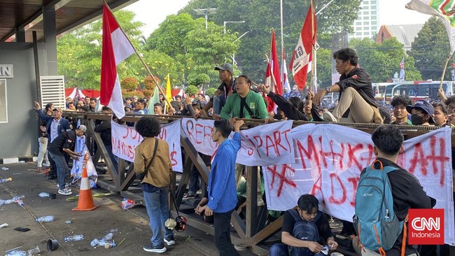 Massa tindakan tolak RUU Pilkada membakar spanduk, botol, kardus di pagar pintu belakang gedung DPR, Jakarta.