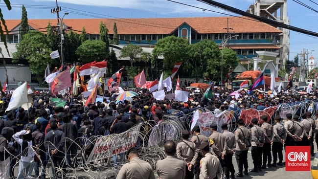 Massa demo RUU Pilkada di Surabaya melempari polisi dengan botol air mineral dan potongan kayu.