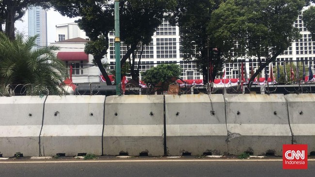 Aparat kepolisian memasang barrier beton nan dilengkapi kawat berduri di depan instansi KPU RI di Jakarta Pusat, Jumat (23/8).