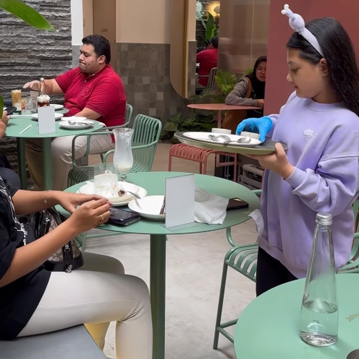 <p>Dalam video yang diunggah pada akun Instagram pribadinya, Arsy dengan sigap membawa pesanan para pelanggan dengan nampan dan sarung tangan. Ia juga terlihat selalu menebarkan senyuman. (Foto: Instagram: @queenarsy)</p>
