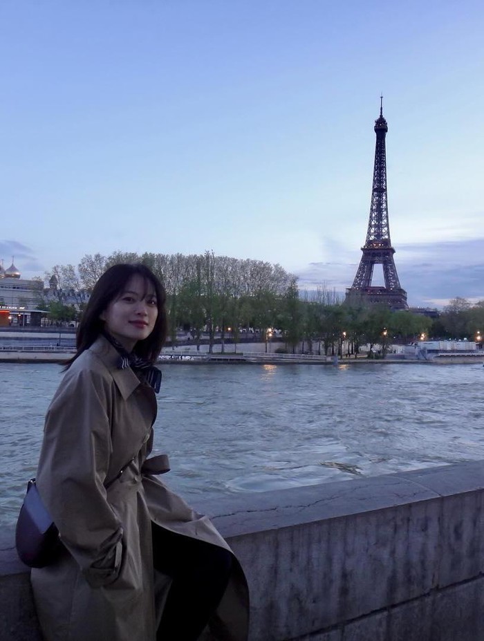 Penampilan Chun Woo Hee ketika liburan di Paris lebih terlihat anggun dalam balutan long coat berwarna beige. Ia terlihat cantik berpose dengan latar Menara Eiffel./ Foto: instagram.com/thousand_wooo