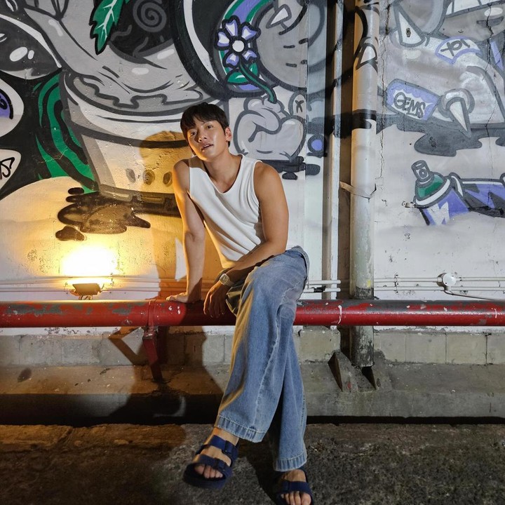 <p>Dalam unggahan fotonya, bintang drakor <em>Welcome to Samdal-ri</em> itu tampak mengenakan kaos tanpa lengan yang dipadukan bersama celana <em>baggy jeans.</em> Ia juga terlihat memakai sandal berwarna hitam. (Foto: Instagram @jichangwook)</p>