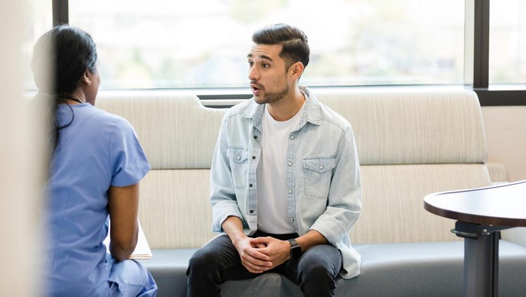 Kesehatan pria While waiting for his wife to return to the hospital room, the young adult man asks the doctor some questions.