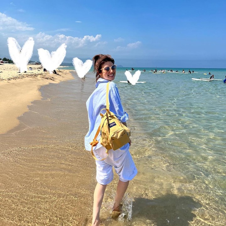 <p>Saat berlibur ke pantai, Nam Ji Hyun memakai<em> beach outfit</em> dengan padu padan kemeja dan celana pendek berwarna biru muda. Ia tak lupa mengenakan <em>sunglasses.</em> (Foto: Instagram @hyuniiiiiii_95917)</p>