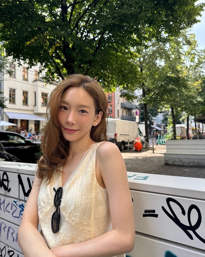 Untuk liburan yang nyaman, Taeyeon memilih tampil natural dengan mengenakan dress tanpa lengan berwarna lemon dengan detail V-neck yang keren dari On&On. / Foto: Elle Korea