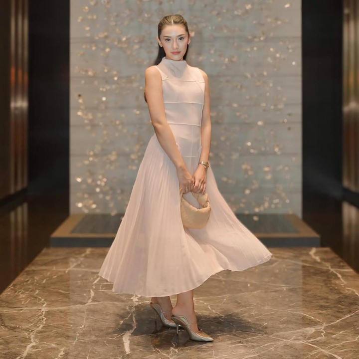 <p>Anissa Aziza tak kalah memesona dengan sleeveless<em> maxi dress</em> yang memiliki aksen kerah <em>turtleneck.</em> Busana itu dipadukan bersama <em>kitten heels</em> keemasan dan <em>handbag</em> berwarna <em>beige.</em> (Foto: Instagram @anissaaziza)</p>