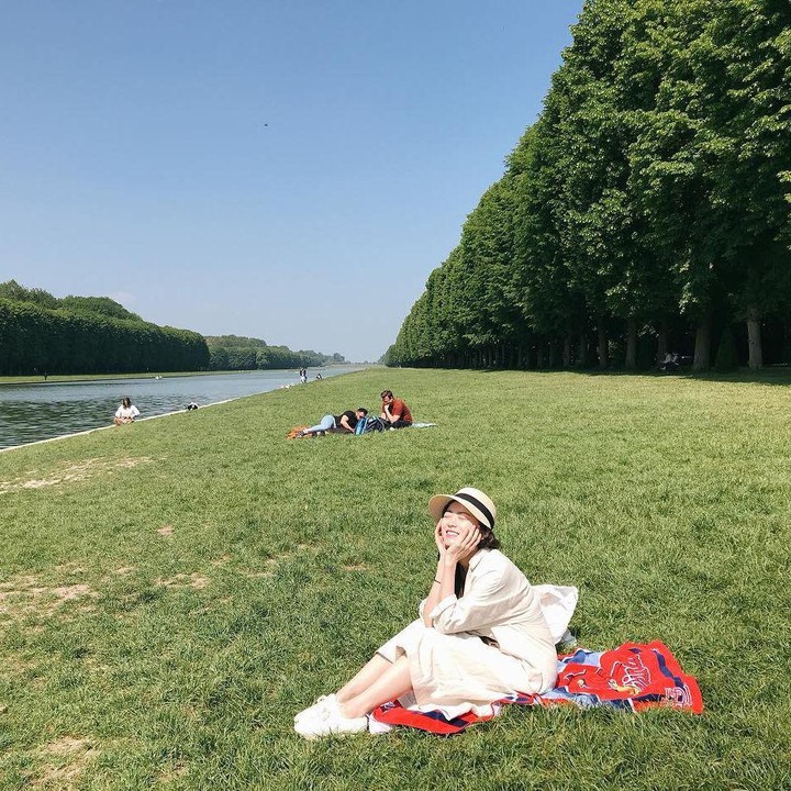 <p>Penampilan Chun Woo Hee saat berlibur di Paris juga tak kalah memesona, nih. Bintang film<em> The Wailing</em> terlihat memesona dengan <em>shirt dress</em> warna putih yang dipadukan dengan <em>bulky sneakers</em> berwarna senada. Ia juga mengenakan topi ketika piknik. (Foto: Instagram @thousand_wooo)</p>
