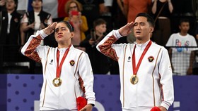 Paris 2024 Paralympics - Badminton - Mixed Doubles SL3-SU5 - Medal Ceremony - Porte de La Chapelle Arena, Paris, France - September 2, 2024Gold medallists Ramdani Hikmat and Leani Ratri of Indonesia salute as they sing the national anthem on the podi
