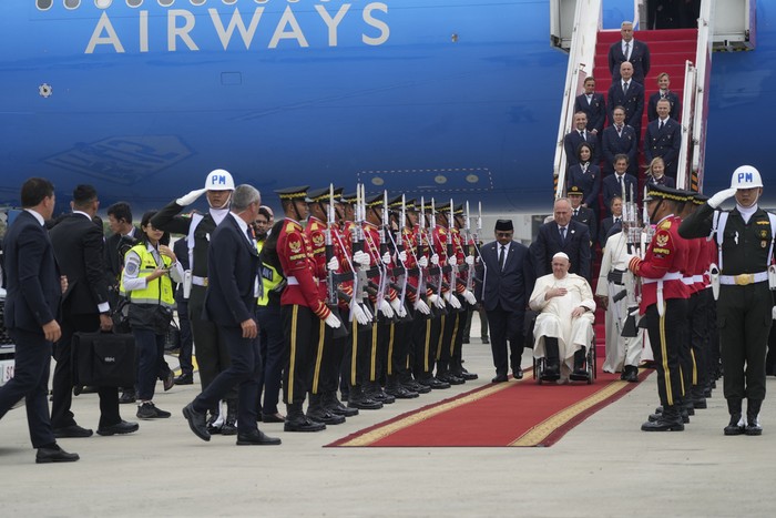 Pope Francis is welcomed by Indonesia's Minister for Religious Affairs Yaqut Cholil Qoumas, at his right, soon after landing at Jakarta's International airport Soekarno Hatta, Tuesday, Sept. 3, 2024. Pope Francis arrived in Indonesia on Tuesday at the start of the longest trip of his pontificate, hoping to encourage its Catholic community and celebrate the tradition of interfaith harmony in a country with the world's largest Muslim population. (AP Photo/Gregorio Borgia)