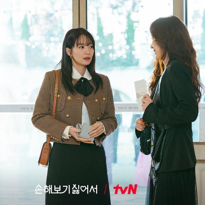 <p>Masih dengan nuansa <em>earthy tone</em> dari warna cokelat, Shin Min Ah memadukan <em>blazer</em> dengan <em>collar shirt</em> berdasi pita. Ia memadukannya bersama rok warna hitam. (Foto: Dok. tvN)</p>