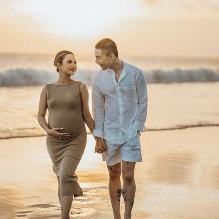 <p>Anggi Marito memilih warna earth tone untuk maternity shoot. Pelantun tembang Tak Segampang Itu ini memanfaatkan keindahan alam Pulau Dewata. Ia dan suaminya tampak mesra menikmati pemandangan pantai saat matahari terbenam. (Foto: @anggimarito)</p>