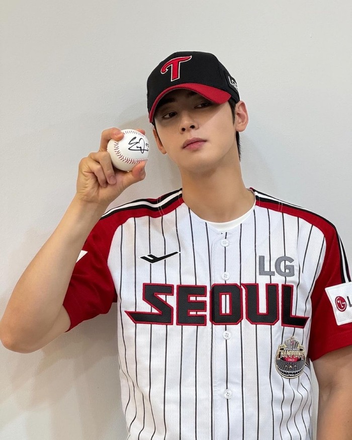 Cha Eun Woo menunjukkan kecintaannya terhadap bisbol yang telah melakukan lemparan pertama sebanyak tiga kali. Ia mengenakan jersey LG Twins dengan sempurna, dan bahkan memakai topi bola yang serasi./ Foto: Elle Korea
