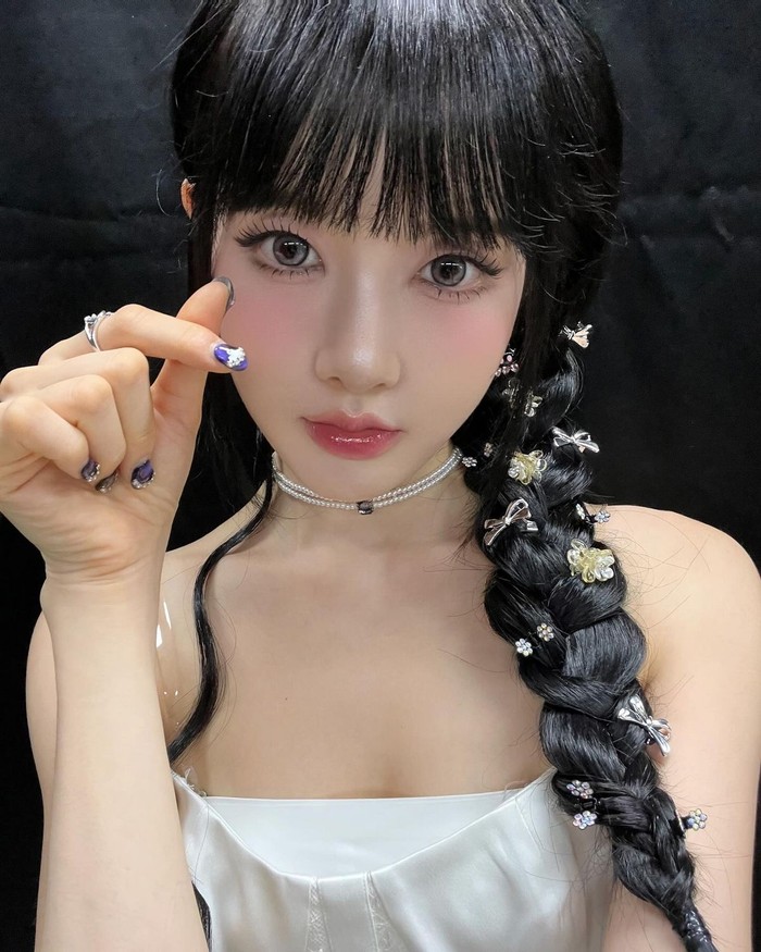 Gaya rambut Sieun StayC tampak cute dan mencolok dengan dikepang di satu sisi, dan dipakaikan banyak jepit lucu berbentuk pita, kupu-kupu, dan bunga seperti di taman. / Foto: Elle Korea