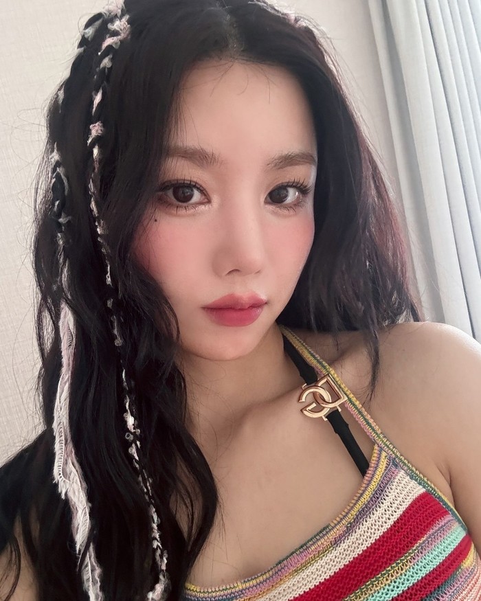 Kwon Eunbi menata sedikit rambut bergelombang alaminya dengan memasang aksesori tali berwarna di bagian atas, dan menggulungnya ke bawah untuk menciptakan gaya rambut bohemian. / Foto: Elle Korea