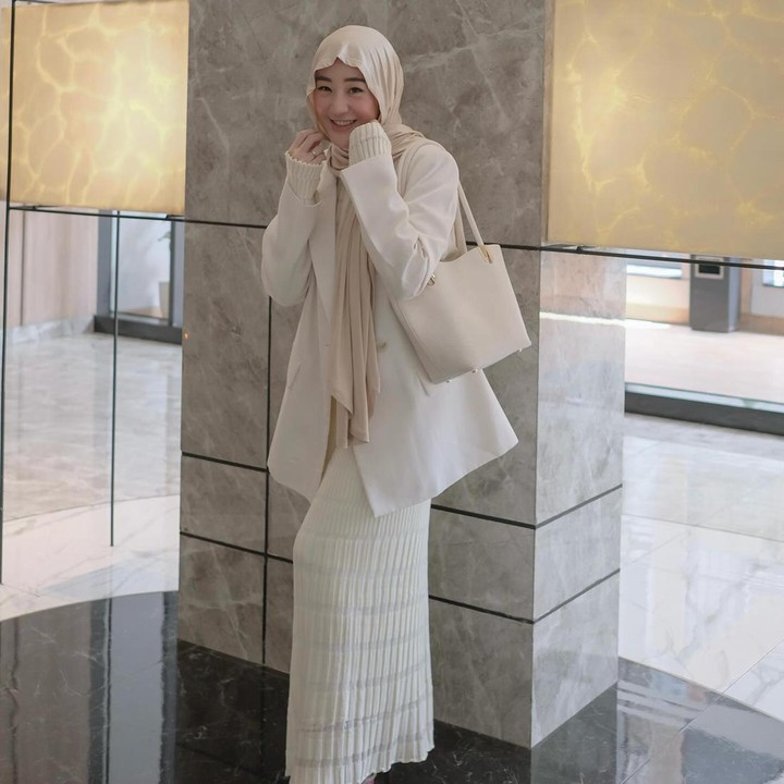 <p>Larissa Chou dikenal memiliki gaya <em>fashion</em> yang modis. Sebagai seorang Muslimah, ia secara konsisten mengenakan hijab dan busana yang tertutup. Hijab pashmina dengan padu padan <em>outfit</em> berwarna lembut menjadi gaya andalan Larissa, Bunda. Seperti pada foto di atas, ia memadukan <em>blazer</em> dengan rok berwarna senada. Ia memberi sentuhan warna merah lewat sepatu yang dikenakan. (Foto: Instagram @larissachou)</p>