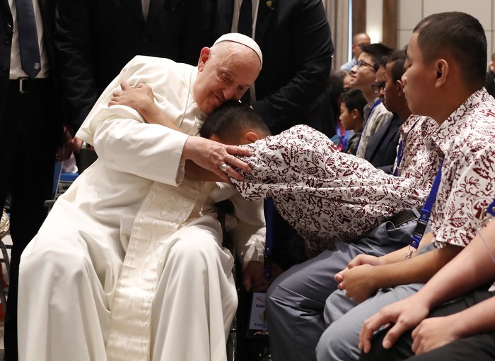 Pope Francis blesses a beneficiary from a charitable organization at the Indonesian Bishops' Conference Headquarters in Jakarta, Indonesia, 05 September 2024.   ADI WEDA/Pool via REUTERS