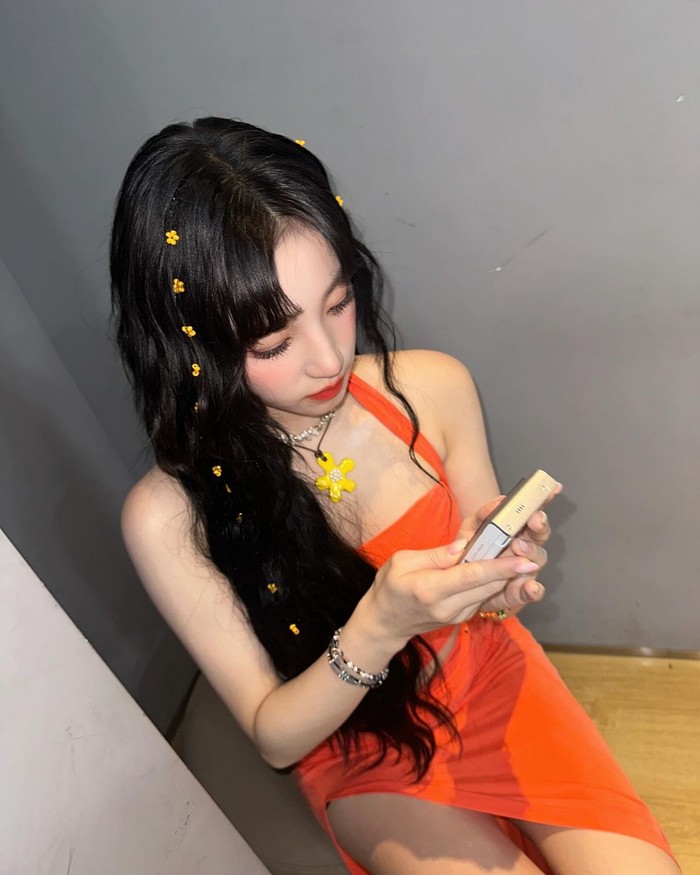 Yuqi (G)I-DLE menciptakan gaya yang eye-catching dengan beberapa hiasan bunga kecil di kedua sisi belahan rambutnya. Tampilannya semakin menyegarkan dengan aksesori yang senada dengan warna dress yang dikenakannya. / Foto: Elle Korea
