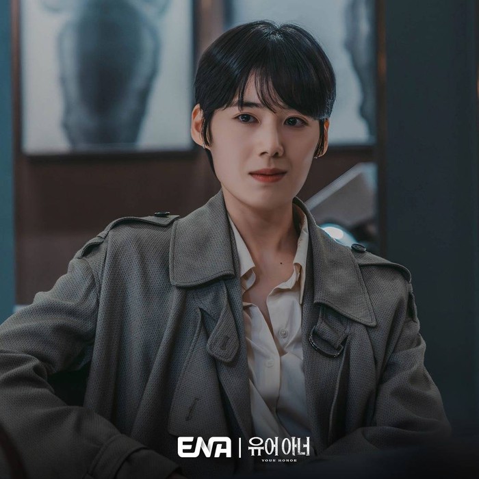 Dengan model rambut bondol serta tatapan tajam dan senyuman intens dalam drama Your Honor, semakin memancarkan aura karismatik Jung Eun Chae sebagai sosok jaksa penuntut yang berpegang teguh pada hukum dan keadilan./ Foto: instagram.com/channel.ena.d
