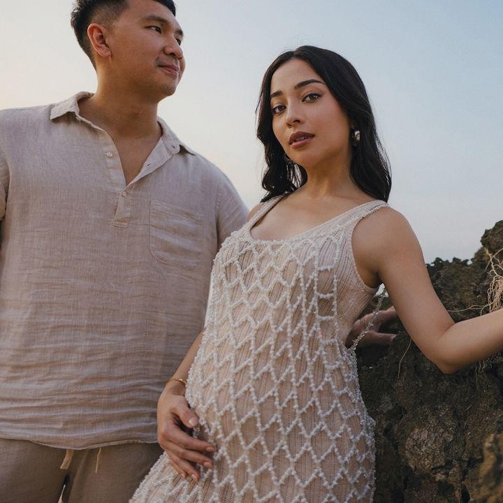 <p>Nikita Willy memamerkan baby bump kehamilan dengan konsep yang anggun. Perempuan 30 tahun ini menggenakan gaun berwarna ivory berjaring. Nikita Willy berpose di pinggir pantai bersama suaminya Indra Priawan, yang juga mengenakan pakaian dengan warna senada. (Foto: Instagram @nikitawillyofficial94)</p>