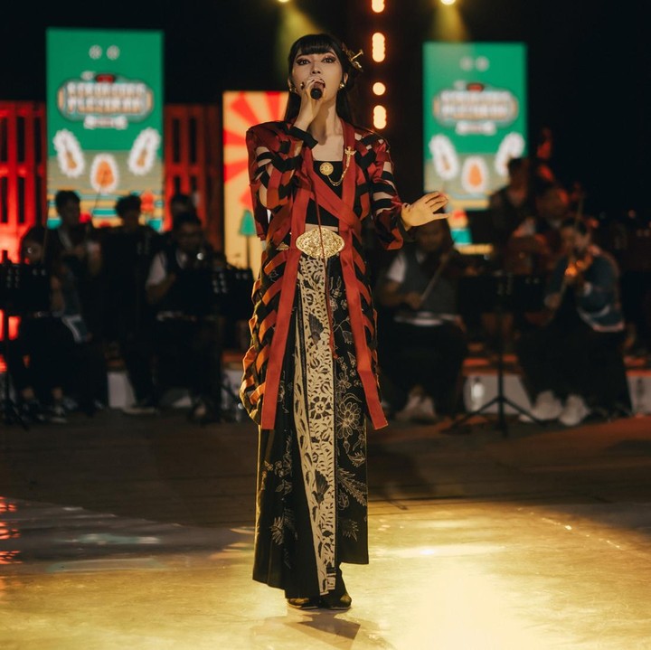 <p>Isyana kerap berkreasi dengan memadukan busana etnik dari berbagai macam corak. Ia terlihat menawan dengan <em>outer</em> <em>stripes</em> yang dipakai untuk menutupi kain lilit bercorak batik. (Foto: Instagram @isyanasarasvati)</p>