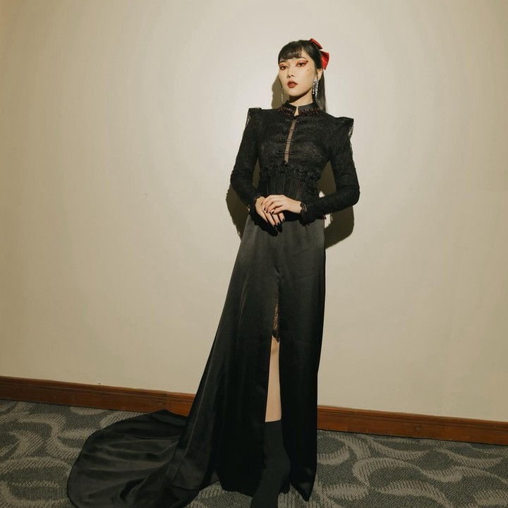 <p>Isyana juga terlihat cantik ketika mengenakan <em>dress</em> hitam beraksen <em>slit.</em> Bagian atasnya memiliki kerah tinggi dari bahan <em>lace</em> yang memberi nuansa klasik. Rambutnya diberi riasan pita berwarna merah. (Foto: Instagram @isyanasarasvati)</p>