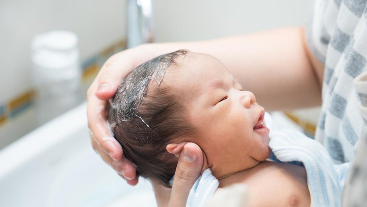 Mencukur rambut bayi