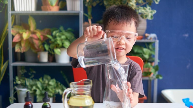 1267813574 Happy little Asian school kid studying science, making DIY Lava Lamp Science Experiment with oil, water and food coloring, Kid-friendly fun and easy science experiments at home concept