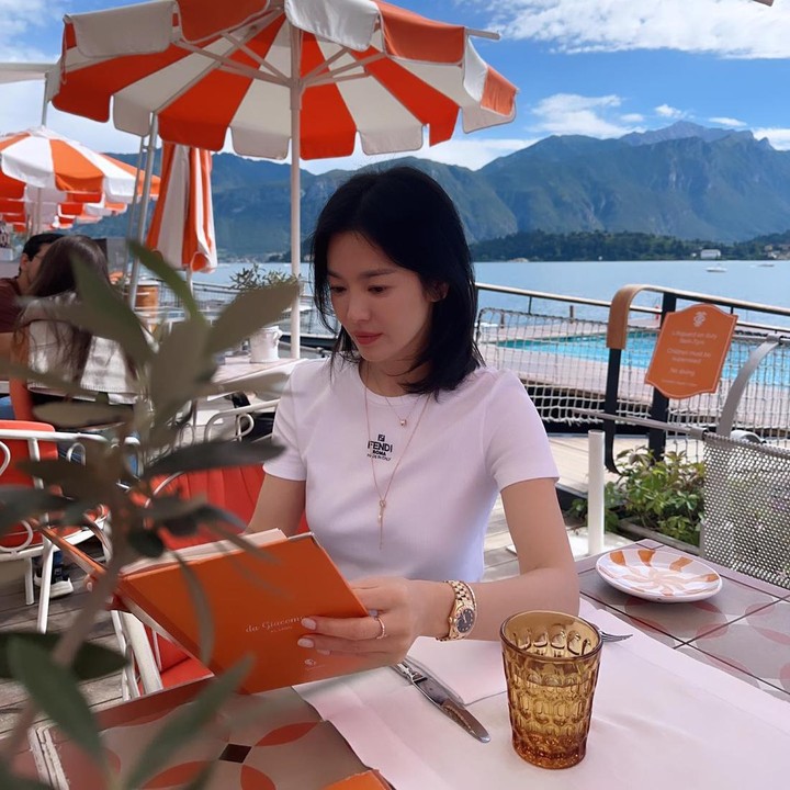 <p>Song Hye Kyo kemudian menikmati suasana Danau Como dengan busana santai berupa <em>t-shirt</em> warna putih. Penampilannya disempurnakan dengan kalung panjang bertumpuk. (Foto: Instagram @kyo1122)</p>