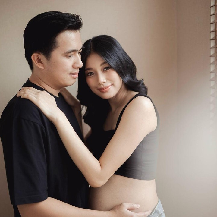<p>Di foto lainnya, Kelvin mengenakan kaos hitam senada dengan pakaian yang dikenakan sang istri. Keduanya berpose romantis dan cukup intim di maternity photoshoot ini, Bunda. (Foto: Instagram @desygenoveva_)</p>