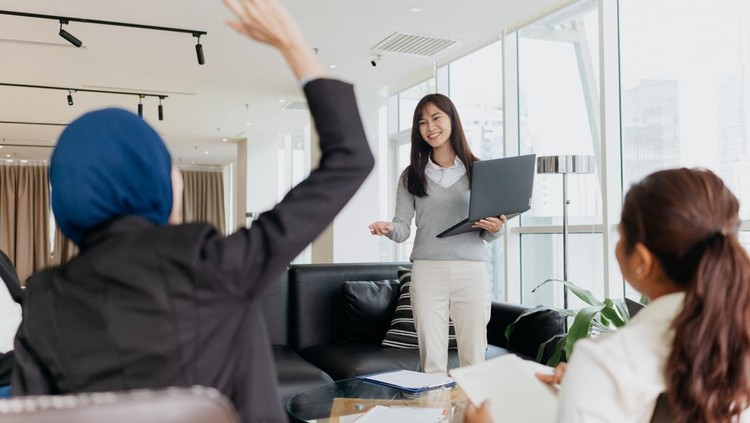 An Asian Chinese woman business entrepreneur giving a speech and presenting ideas and strategies to her team in office