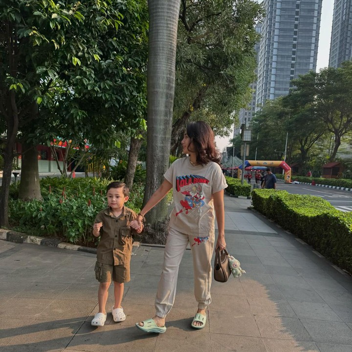 <p>Ketika momong anak, Ussy Sulistiawaty tampil santai dengan <em>outfit</em> kasual dan handbag cokelat yang dipercantik dengan boneka Labubu. (Foto: Instagram @ussypratama)</p>