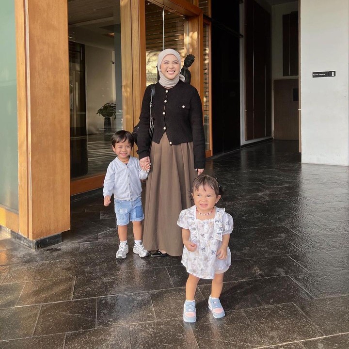 <p>Pada salah satu unggahan, Kesha juga terlihat memomong kedua anaknya dengan <em>sweater</em> hitam dan rok cokelat. Tampilannya pun semakin <em>fashionable</em> dengan <em>shoulder bag</em> hitam serta kerudung warna senada. (Foto: Instagram: @kesharatuliu05)</p>