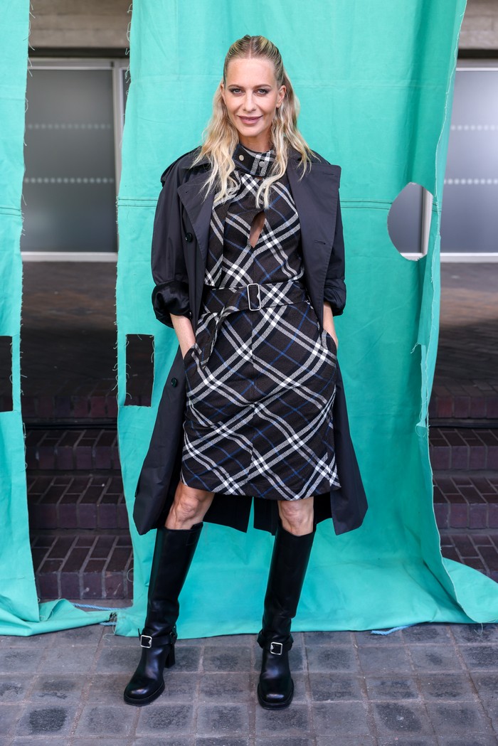 Bergaya dengan plaid dress tak harus minim styling. Poppy Delevingne buktikan bahwa midi dress bermotif khas Burberry itu layak disandingkan coat dan knee-high boots beraksen buckle yang juga dijumpai pada gaun/ Foto: Dave Benett/Getty Images