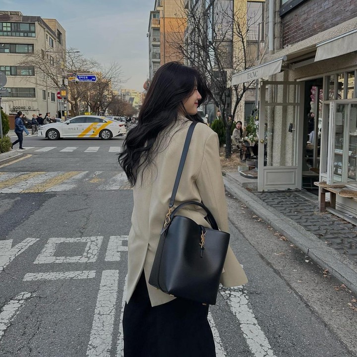 <p>Kombinasi <em>oversized blazer</em> bernuansa<em> earth tone</em> dan rok warna hitam juga cocok diterapkan untuk busana kerja, lho. Sempurnakan penampilan dengan tas warna hitam polos seperti Jang Gyu Ri. (Foto: Instagram @gyurious_j)</p>
